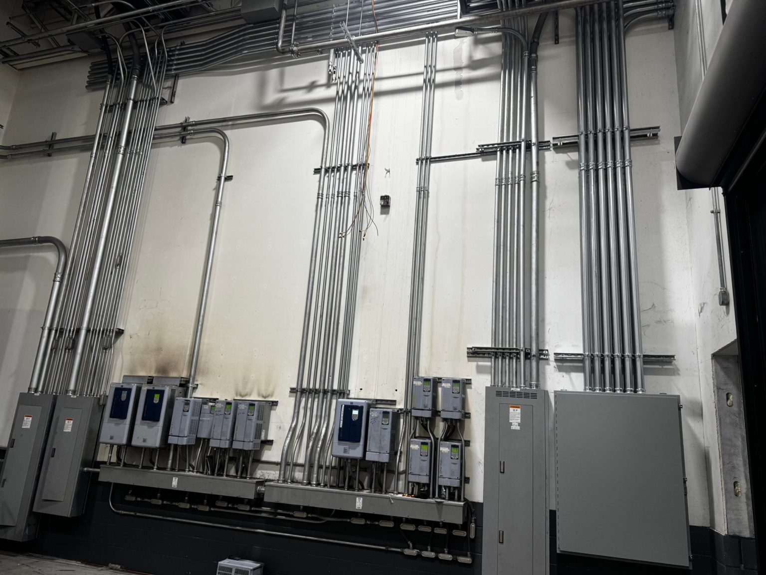 Variable frequency drives and rigid conduit runs on a plant wall