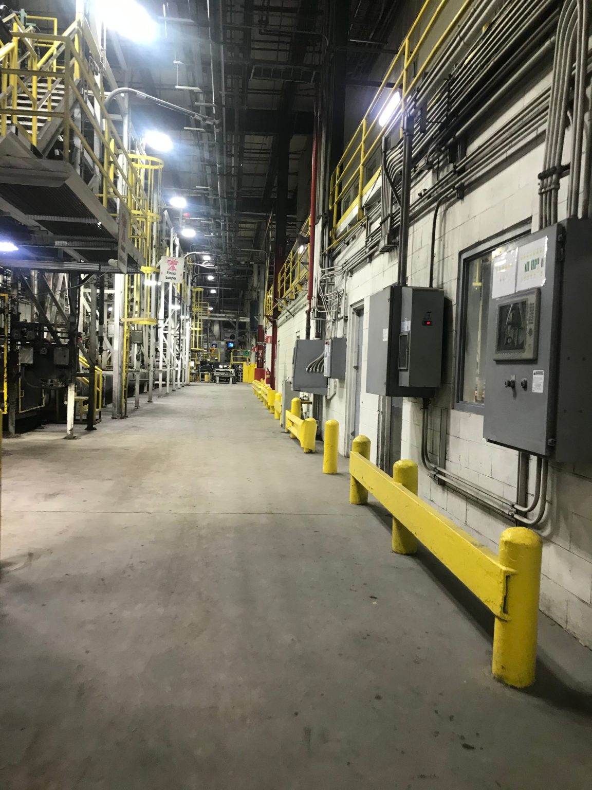 Plastics plant aisle with control panels and guardrails
